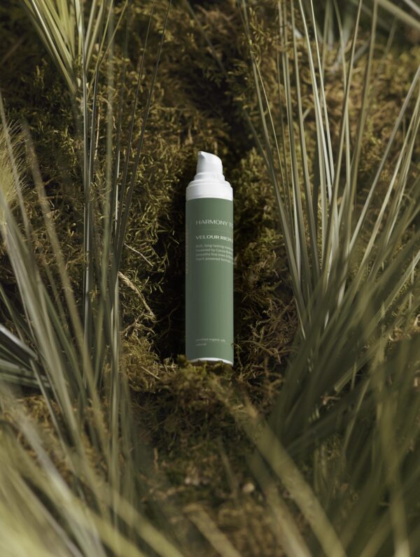 Velour Rich Cream airless pump bottle surrounded by natural moss and greenery